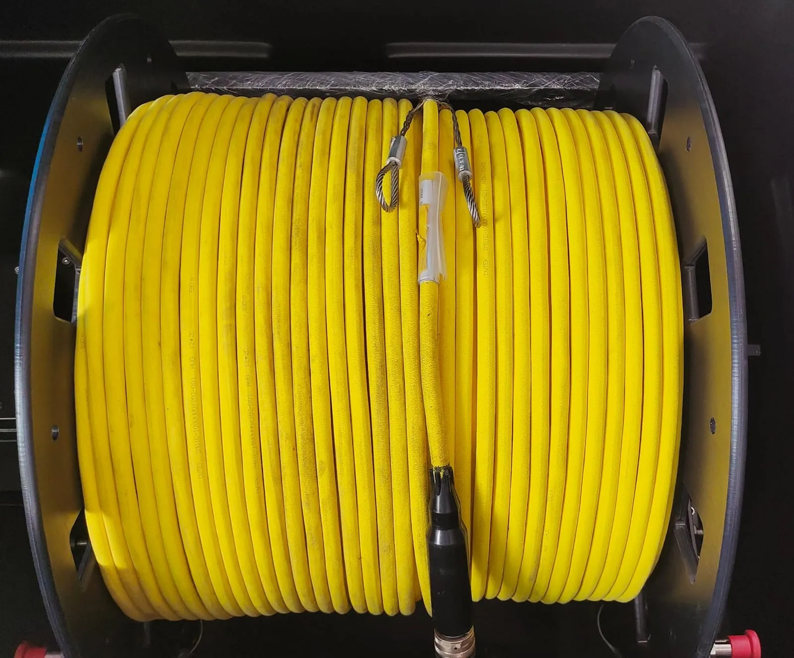 Yellow ROV tether cable wound on a storage reel with its termination connector